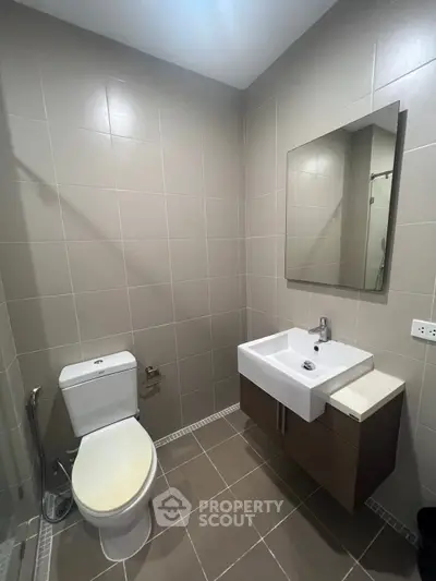 Modern bathroom with sleek fixtures and neutral tiles, perfect for a contemporary home.
