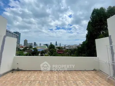 Spacious balcony with stunning cityscape view and clear blue sky.