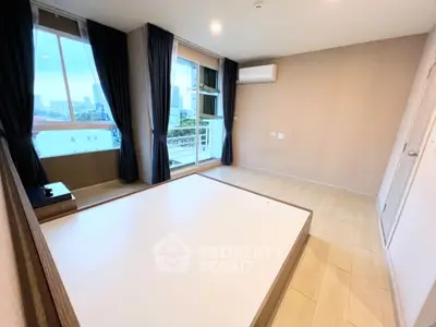 Spacious bedroom with large windows and city view, featuring modern wood flooring and air conditioning.