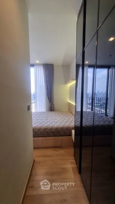 Modern bedroom with city view and sleek design, featuring floor-to-ceiling windows and stylish furnishings.