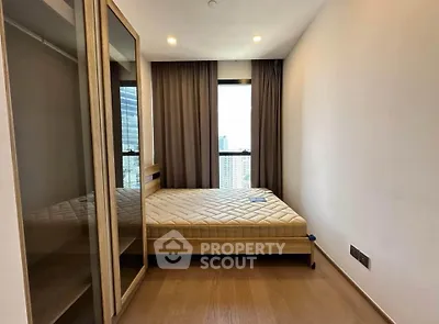 Modern bedroom with large window and wooden flooring in high-rise apartment