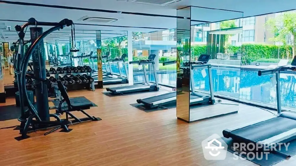 Modern gym with pool view in luxury residential complex