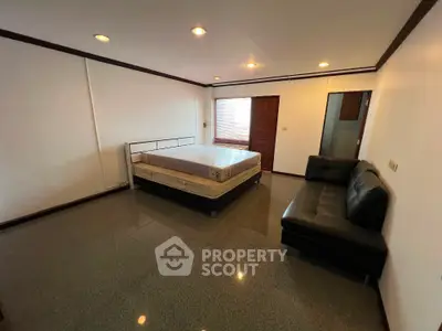 Spacious bedroom with modern furnishings and ample natural light
