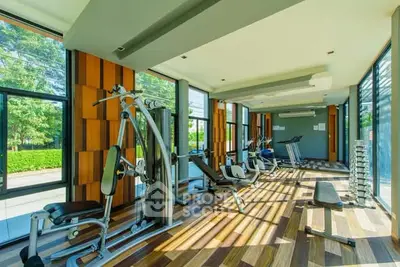Spacious and modern gym with state-of-the-art equipment and large windows offering scenic views.