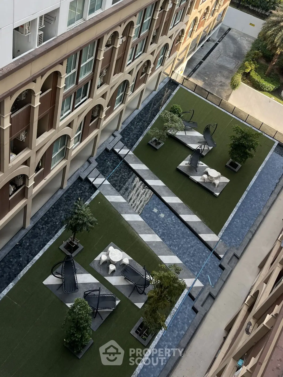 Stunning aerial view of modern building courtyard with stylish outdoor seating and lush greenery.