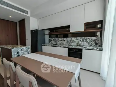 Modern kitchen with sleek cabinetry and marble backsplash in a stylish apartment.