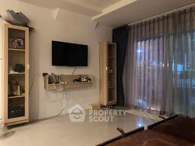 Modern living room with wall-mounted TV and glass sliding doors