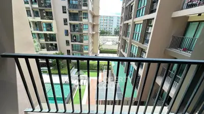 Modern apartment balcony with pool and garden view in urban setting