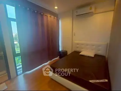 Cozy bedroom with modern decor and large window for natural light.