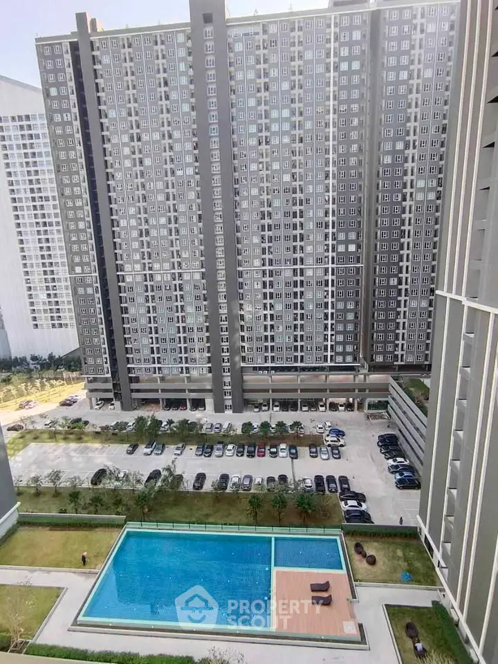 Modern high-rise apartment building with pool and parking view, ideal for urban living.