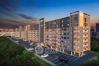Modern apartment building with ample parking and city skyline view at dusk.