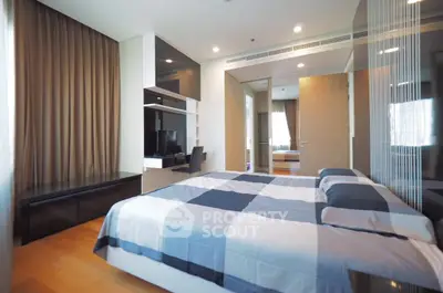 Modern bedroom with stylish decor and ample natural light, featuring a sleek workspace and cozy bedding.