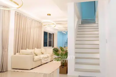 Modern living room with elegant staircase and cozy seating area