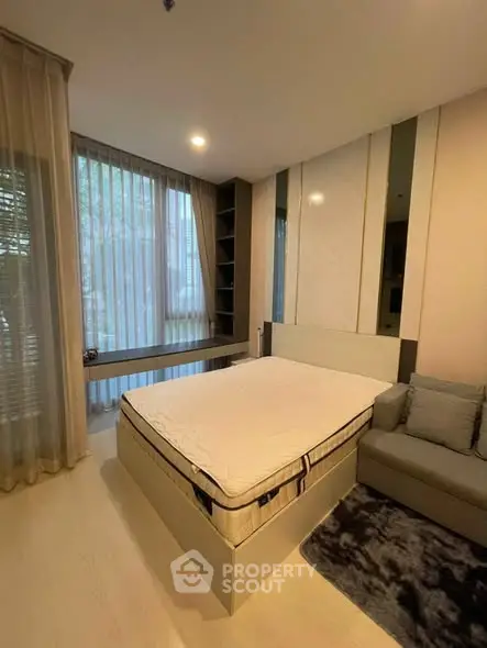 Modern bedroom with large windows, cozy bed, and stylish decor in a contemporary apartment.