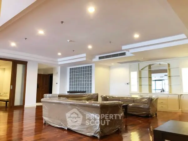 Spacious modern living room with elegant wooden flooring and stylish ceiling lights.