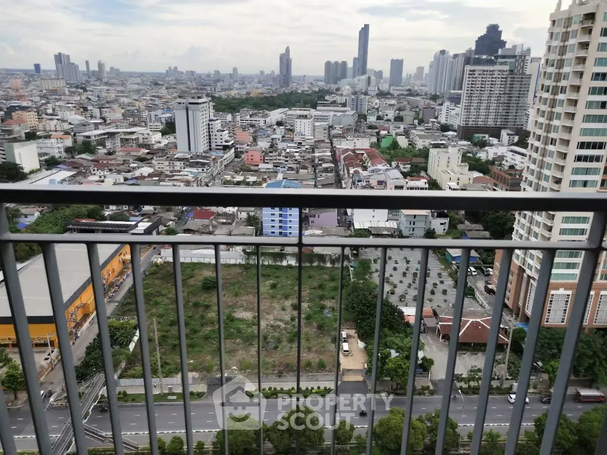 Stunning cityscape view from high-rise balcony overlooking urban skyline and green spaces.