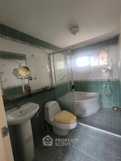 Spacious bathroom with modern fixtures and corner bathtub in a stylish home.