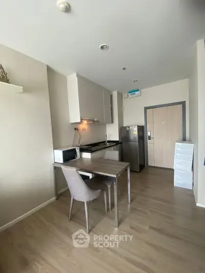 Modern kitchen with dining area, featuring sleek appliances and contemporary design.