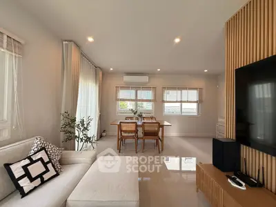 Modern living room with sleek furniture and natural light, featuring a cozy dining area and stylish decor.
