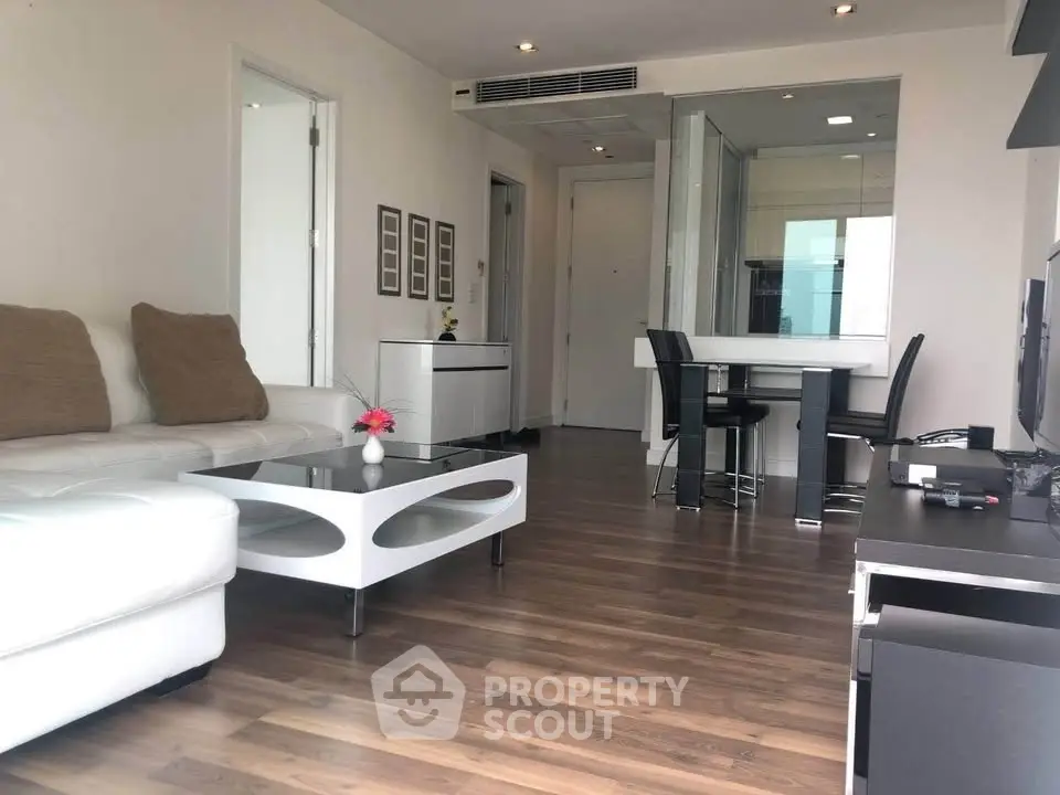 Modern living room with sleek furniture and open layout, featuring hardwood floors and stylish decor.