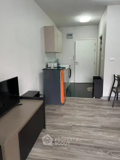 Modern apartment interior with open layout, featuring sleek kitchen and cozy living area.