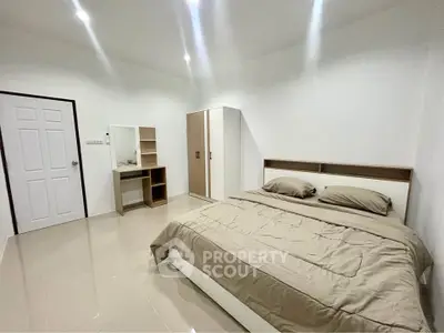 Spacious bedroom with modern furniture and neutral tones, perfect for relaxation.