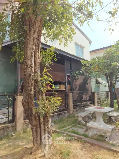 Charming suburban home with lush garden and outdoor seating area, perfect for relaxation.