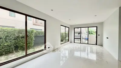 Spacious modern living room with large windows and garden view
