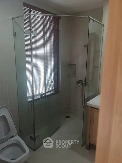Modern bathroom with glass shower enclosure and sleek design.