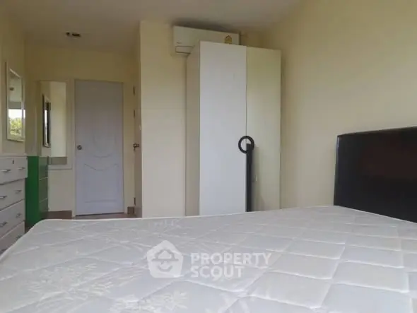 Cozy bedroom with white wardrobe and air conditioning unit, perfect for relaxation.