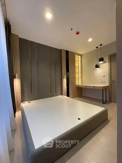 Modern bedroom with stylish lighting and sleek design, perfect for urban living.