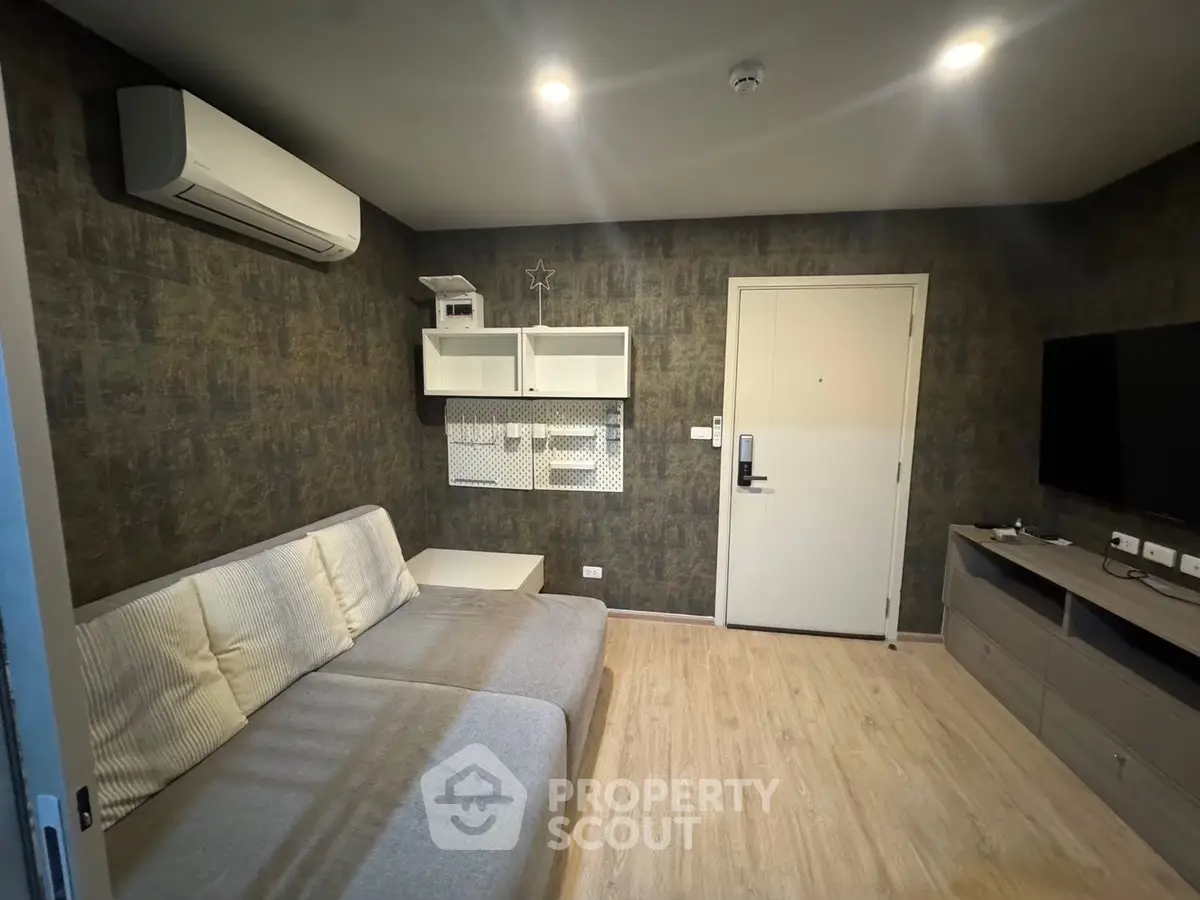 Modern living room with sleek design and cozy ambiance, featuring a comfortable sofa and wall-mounted TV.