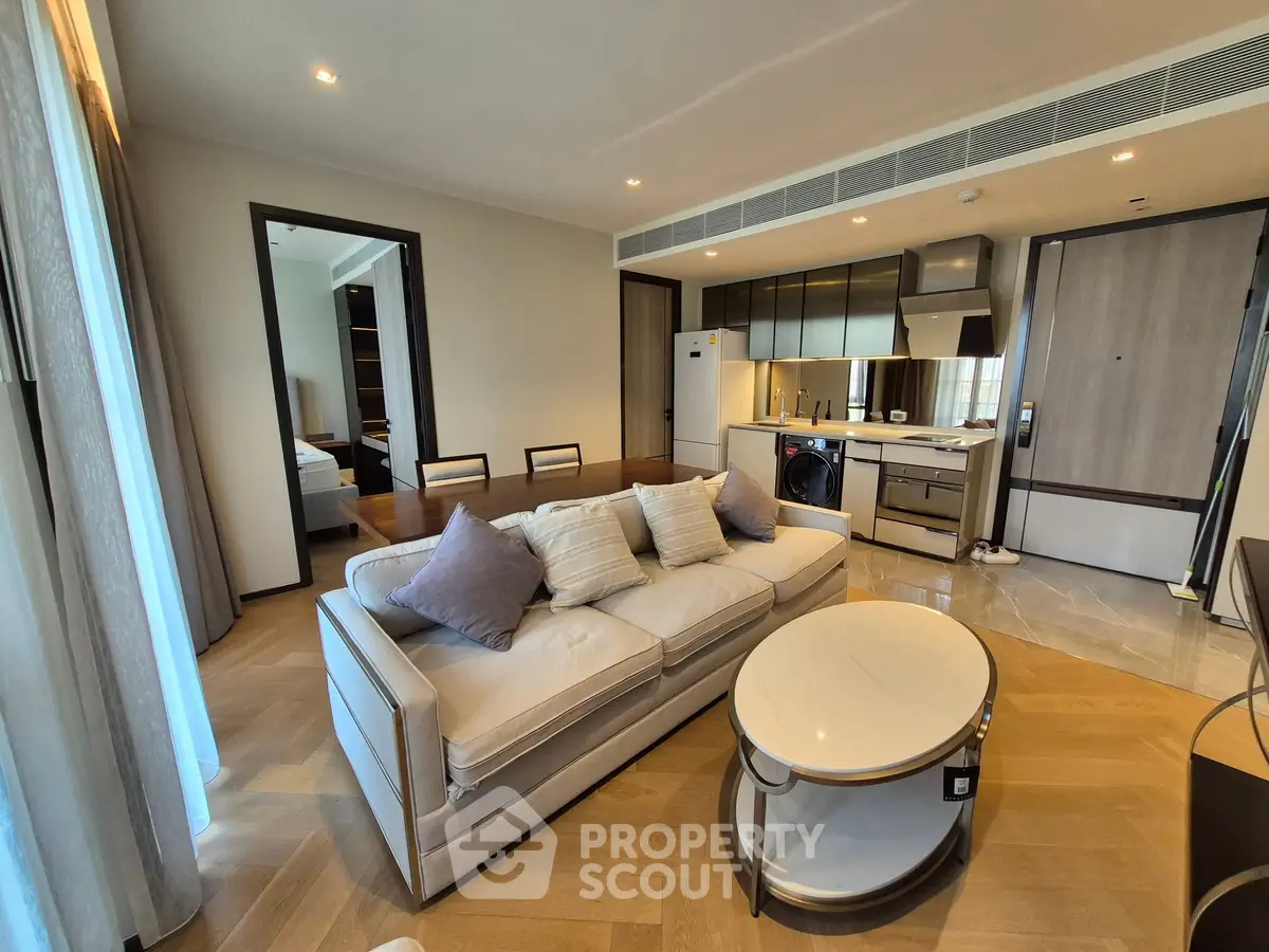 Luxurious open-plan living room with modern kitchen and elegant furnishings in a high-end apartment.