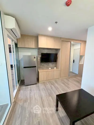 Modern living room with wooden flooring and built-in TV unit in a stylish apartment.