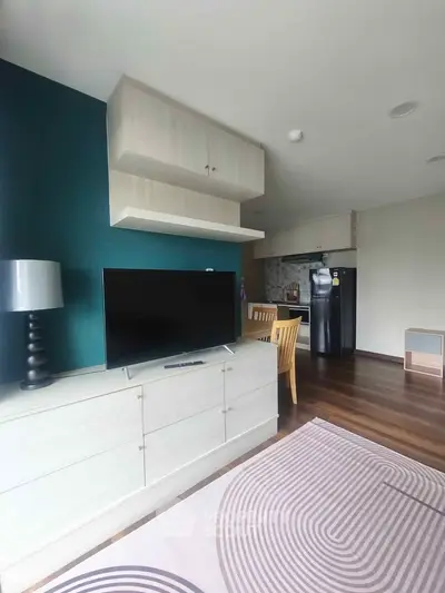 Modern living room with stylish decor and open kitchen layout, featuring sleek furniture and hardwood floors.