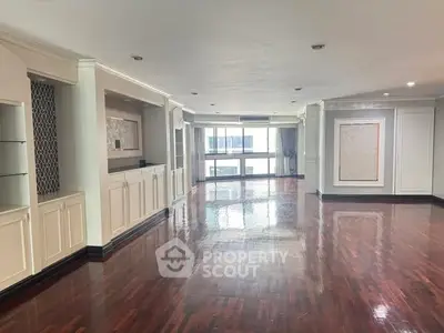 Spacious and elegant living room with polished wooden floors and large windows.