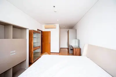 Spacious modern bedroom with minimalist design and ample natural light.