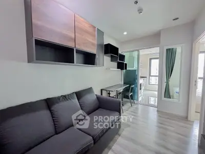 Modern living room with sleek furniture and open layout, featuring a cozy sofa and stylish shelving.