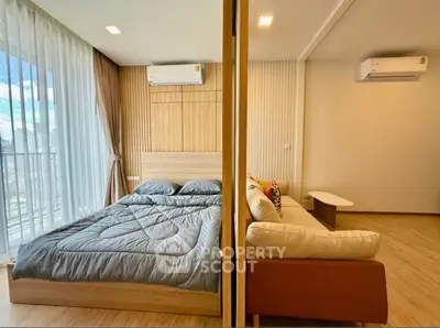 Modern bedroom with adjoining living area featuring stylish decor and natural light