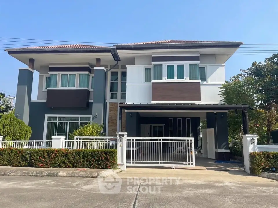 Modern two-story house with gated driveway and landscaped garden