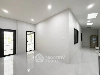 Spacious modern interior with sleek tile flooring and large windows, perfect for natural light.