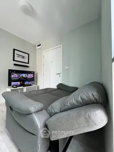 Modern living room with sleek gray sofa and wall-mounted TV for ultimate relaxation.