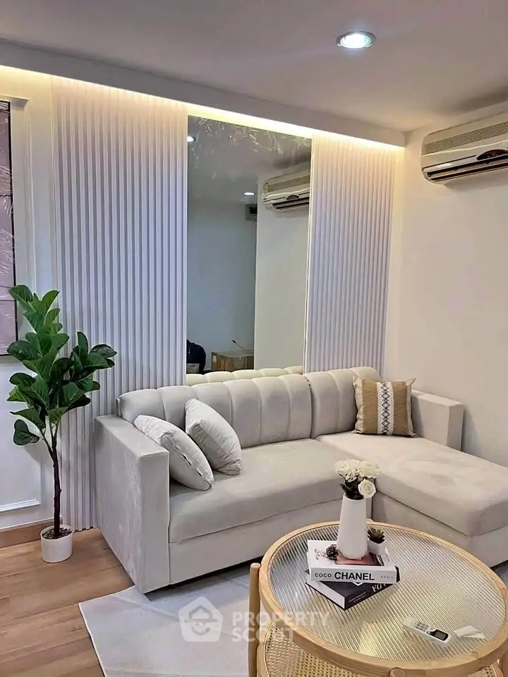 Modern living room with elegant sofa, stylish decor, and air conditioning, perfect for relaxation.
