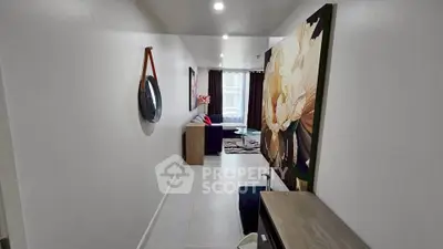 Modern hallway leading to a stylish living room with contemporary decor and large artwork.