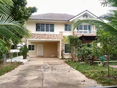 Charming two-story house with lush garden and spacious driveway, perfect for family living.