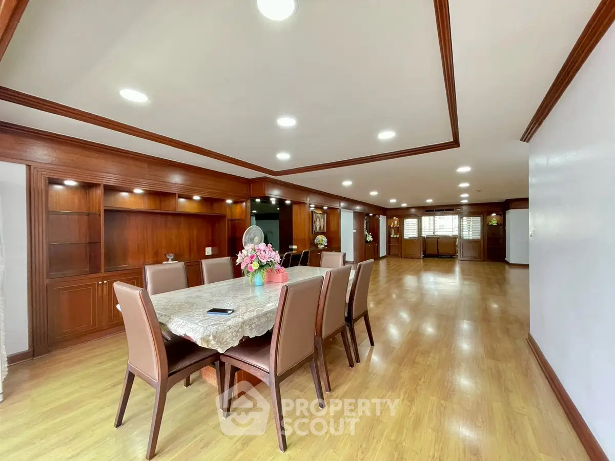 Spacious dining area with elegant wooden flooring and built-in cabinets, perfect for family gatherings.