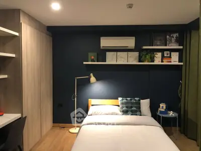 Modern bedroom with stylish decor and cozy ambiance, featuring a comfortable bed and sleek shelving.