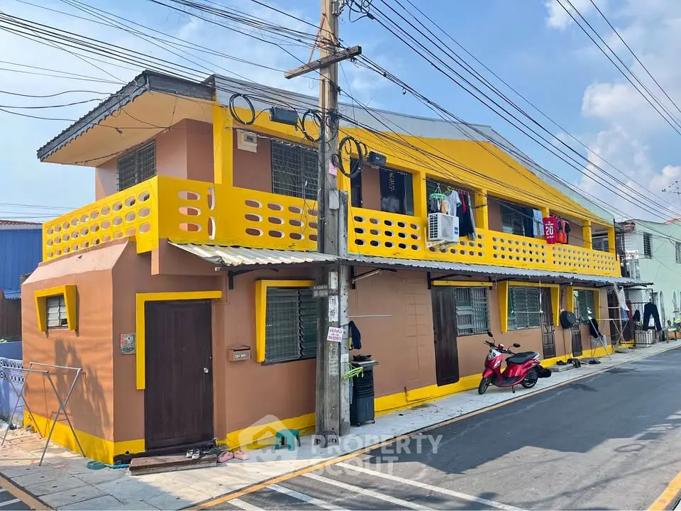 Vibrant two-story building with yellow accents and street view