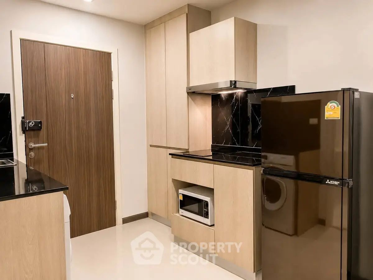 Modern kitchen with sleek cabinetry and stainless steel appliances in a stylish apartment.