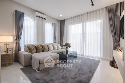 Elegant living room with plush sofa, modern decor, and abundant natural light.